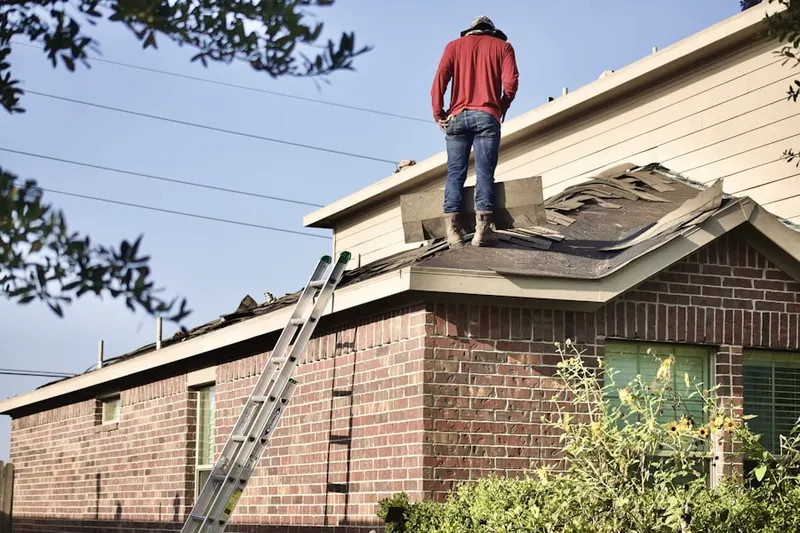 Professional roofer working on a residential roof in Weequahic